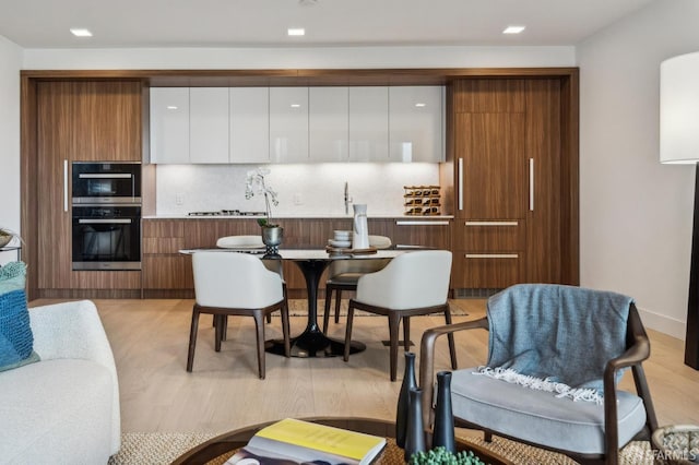 2177 3rd St Unit 421, San Francisco, CA 94107 - kitchen with modern cabinets, backsplash, white cabinetry, and double oven