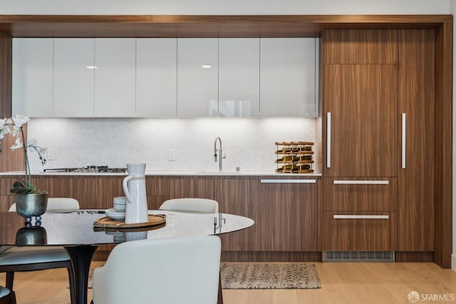 2177 3rd St Unit 421, San Francisco, CA 94107 - kitchen with modern cabinets, a sink, light wood-style floors, and tasteful backsplash