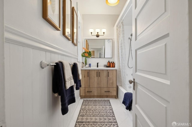full bath featuring a wainscoted wall, vanity, shower / tub combo, and tile patterned floors