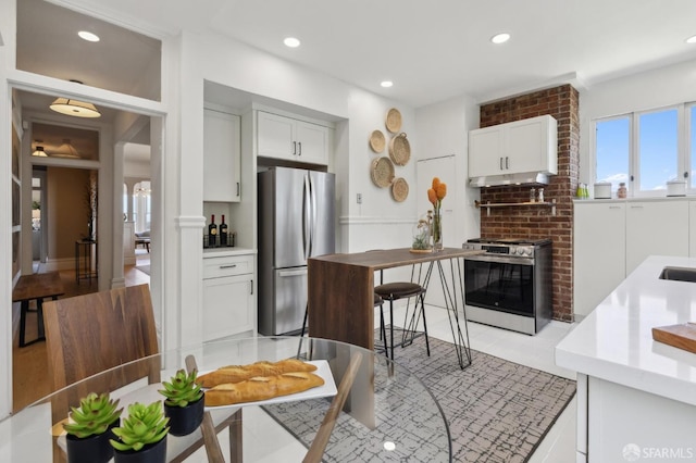 kitchen with appliances with stainless steel finishes, under cabinet range hood, white cabinetry, light countertops, and recessed lighting