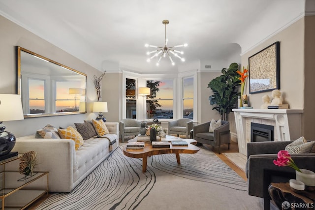 living area with a chandelier, a tile fireplace, and wood finished floors
