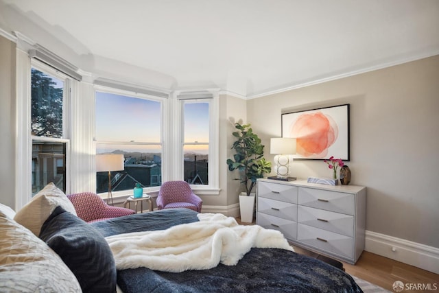 bedroom with baseboards, light wood-style flooring, and ornamental molding