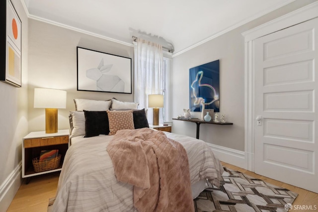 bedroom with crown molding, light wood-type flooring, and baseboards