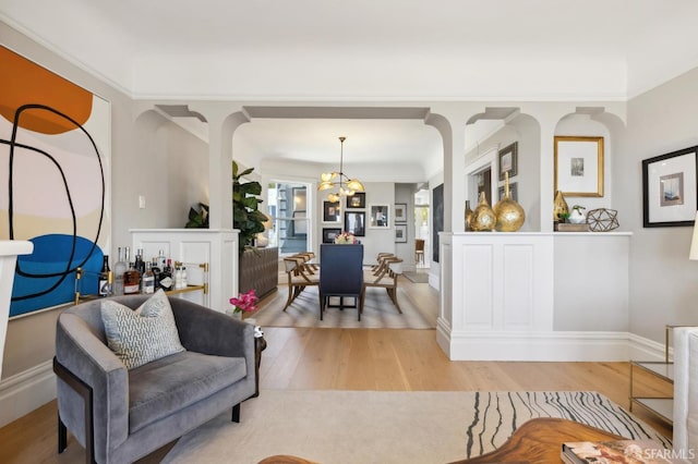 living room with a chandelier, light wood-style floors, and baseboards