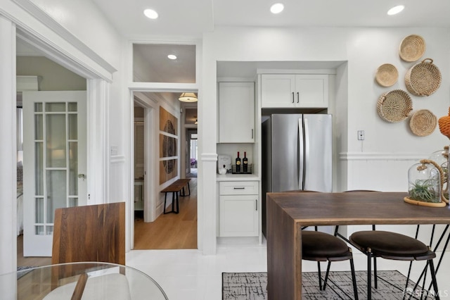 kitchen with freestanding refrigerator, white cabinets, recessed lighting, light countertops, and french doors