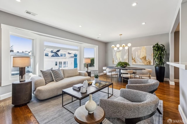 living room with wood-type flooring and a chandelier