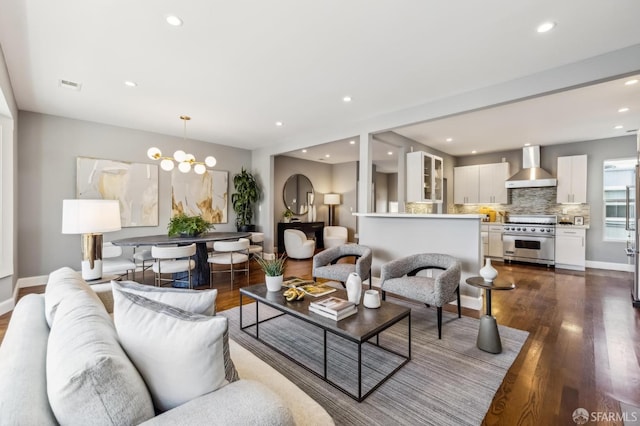 living room with dark hardwood / wood-style floors and an inviting chandelier