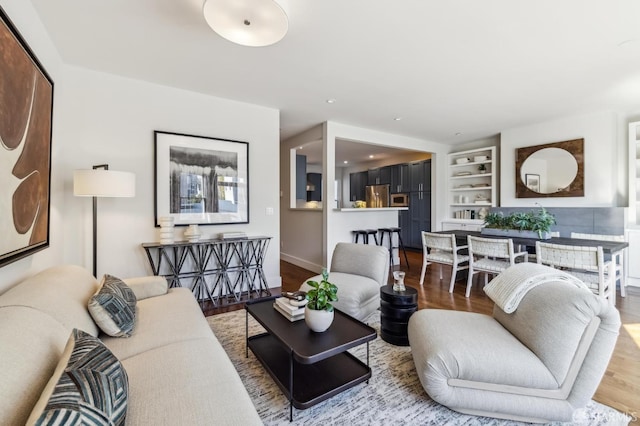 living room featuring hardwood / wood-style flooring and built in shelves