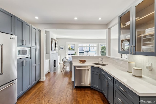 kitchen featuring sink, dark wood-type flooring, appliances with stainless steel finishes, gray cabinetry, and backsplash