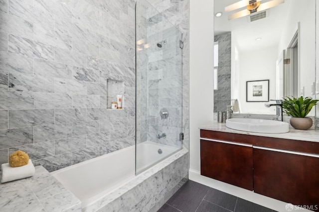 bathroom featuring tile patterned floors, vanity, and tiled shower / bath combo