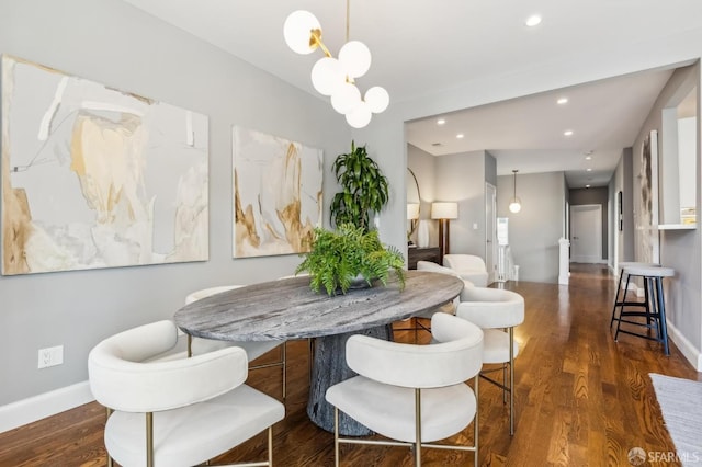 dining space with dark hardwood / wood-style flooring and a notable chandelier