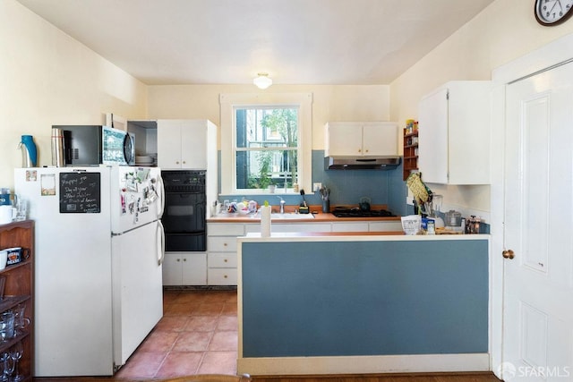 kitchen with under cabinet range hood, a peninsula, white cabinets, black appliances, and tasteful backsplash