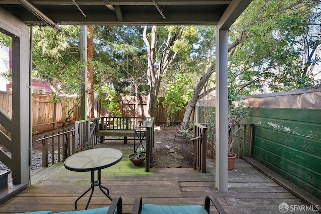 wooden terrace with a fenced backyard