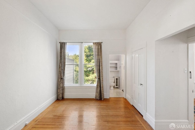 spare room with light wood-style floors and baseboards