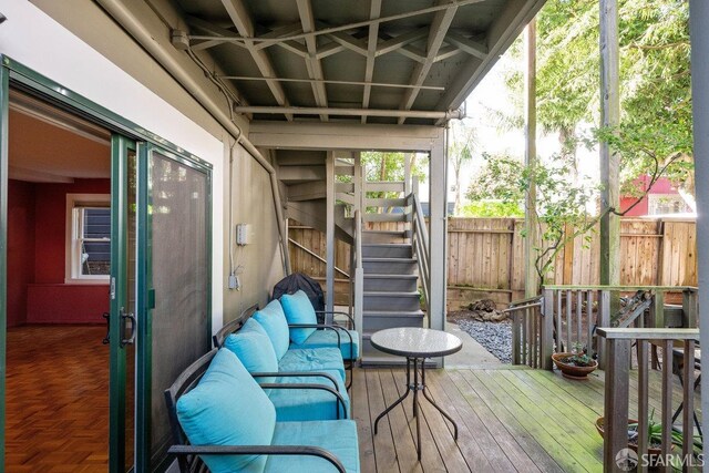 wooden deck featuring stairway, fence, and outdoor lounge area