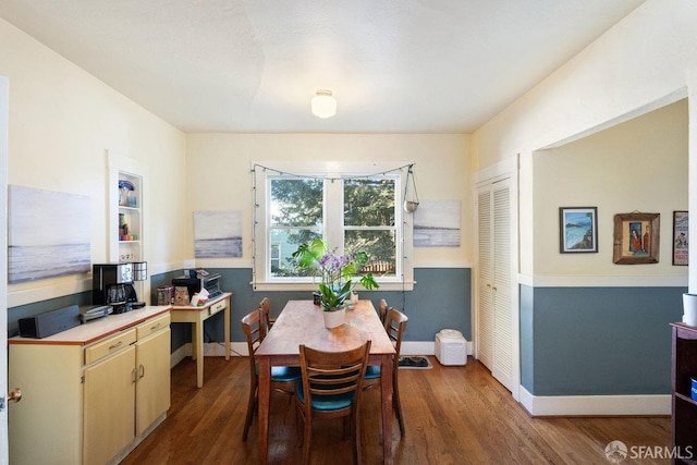 dining room featuring built in features, baseboards, and wood finished floors