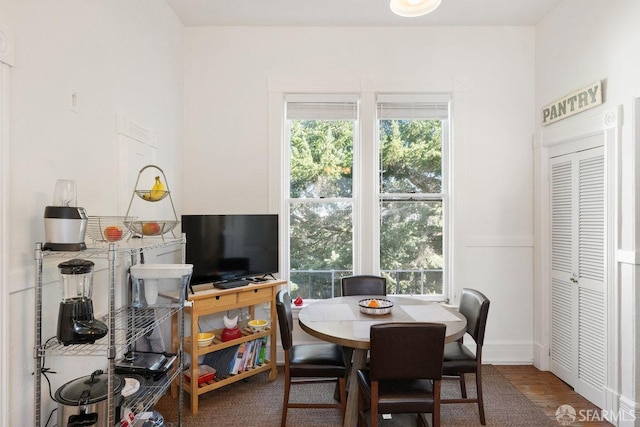 dining area featuring a wainscoted wall, plenty of natural light, and wood finished floors