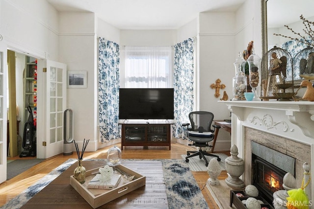 living area with a tiled fireplace and wood finished floors