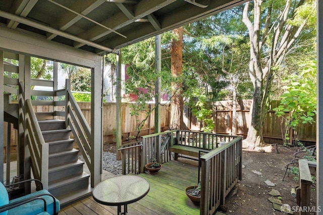 wooden terrace featuring a fenced backyard and stairs