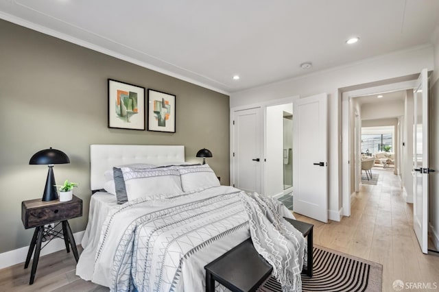 bedroom with ornamental molding and light wood-type flooring