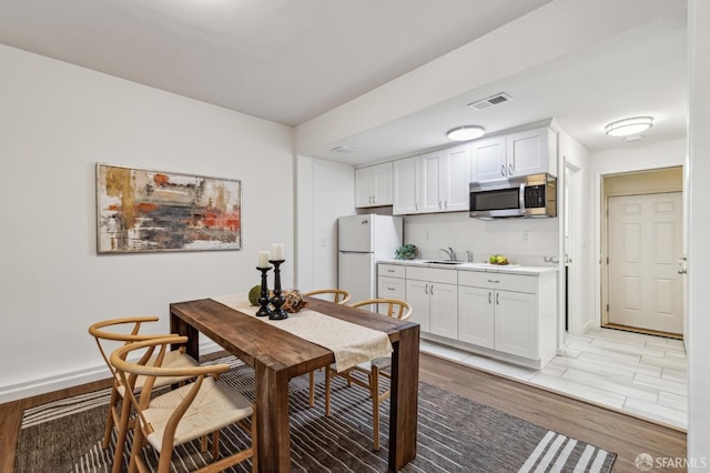 dining space with sink and light hardwood / wood-style floors