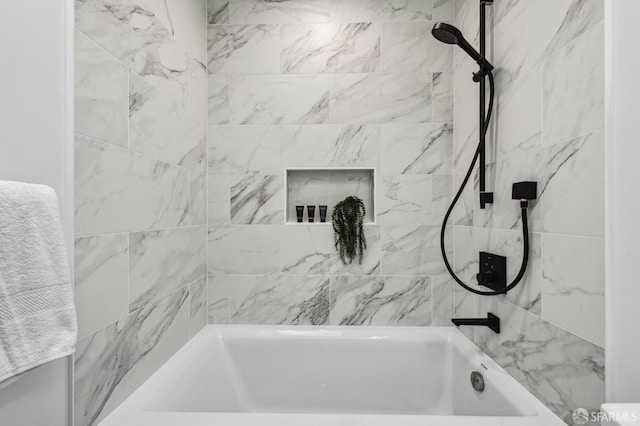 bathroom featuring tiled shower / bath