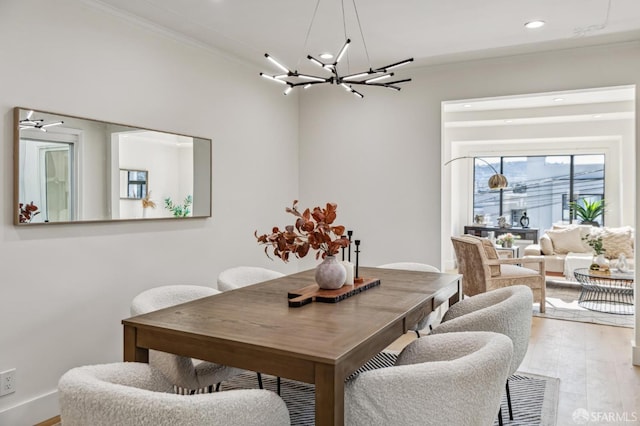 dining space featuring an inviting chandelier, crown molding, and light hardwood / wood-style floors