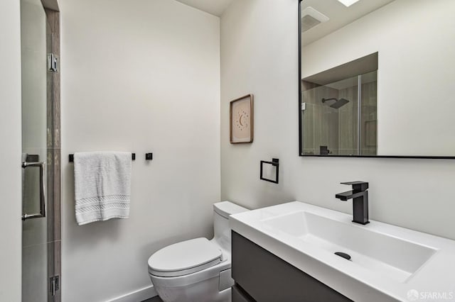 bathroom featuring vanity, a shower with door, and toilet