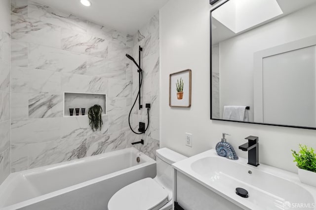 full bathroom featuring vanity, tiled shower / bath combo, a skylight, and toilet