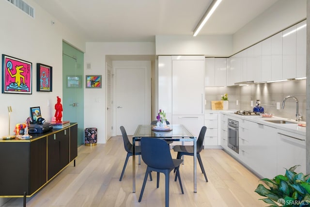88 Arkansas St Unit 528, San Francisco, CA 94107 - kitchen with modern cabinets, a sink, stainless steel appliances, light wood-style flooring, and white cabinetry