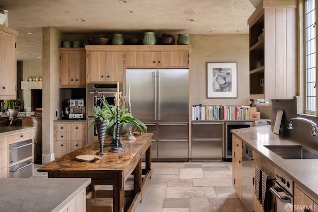 kitchen featuring light brown cabinets, stainless steel appliances, wine cooler, and sink