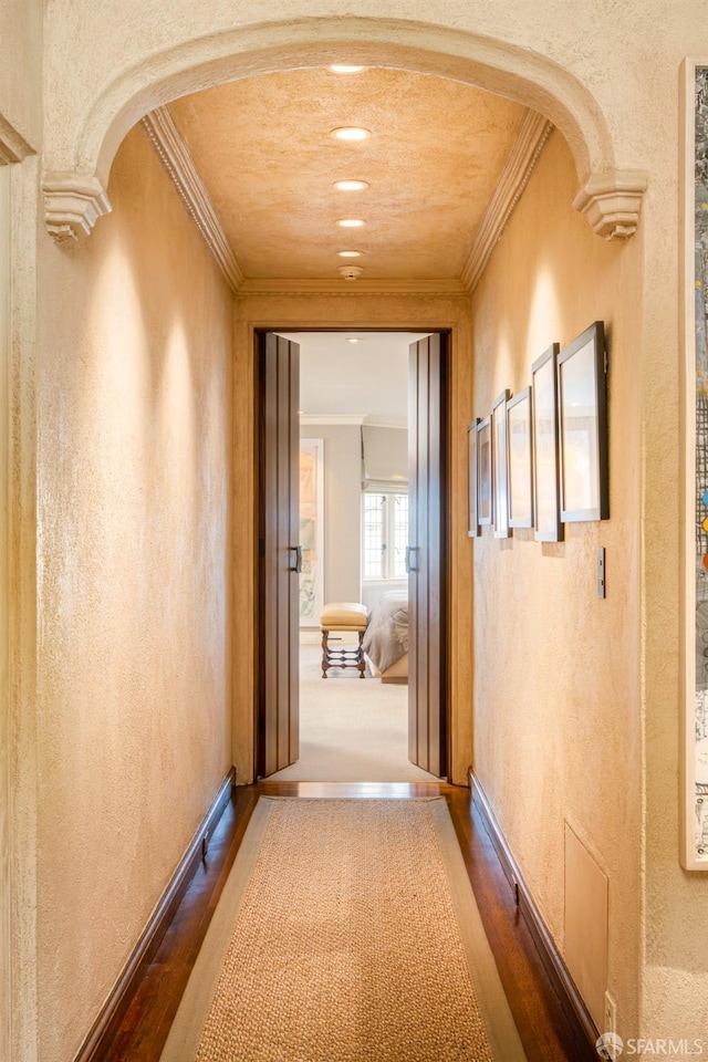 hallway featuring decorative columns, crown molding, and hardwood / wood-style flooring