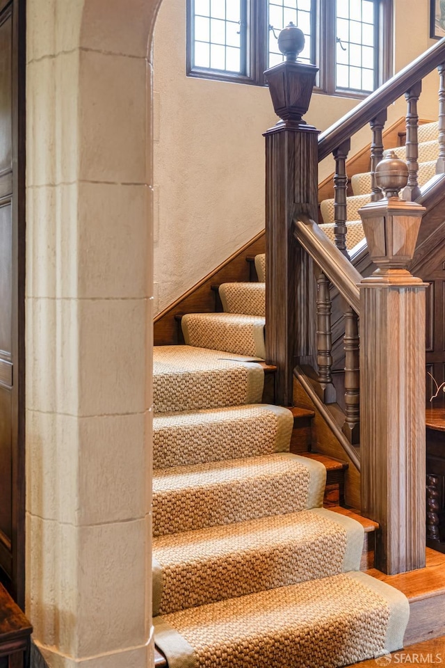 stairs featuring plenty of natural light and wood-type flooring