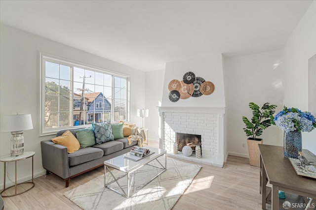 living room featuring light wood-type flooring and a fireplace