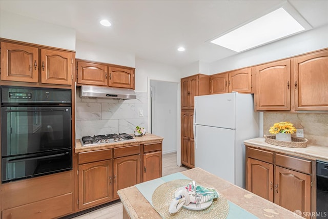 kitchen with decorative backsplash, light hardwood / wood-style flooring, and black appliances