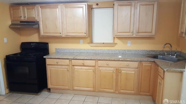 kitchen with gas stove, light stone countertops, sink, light brown cabinetry, and light tile patterned flooring