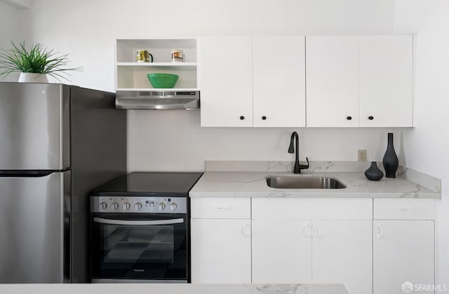 kitchen with range hood, stainless steel appliances, light stone countertops, and sink