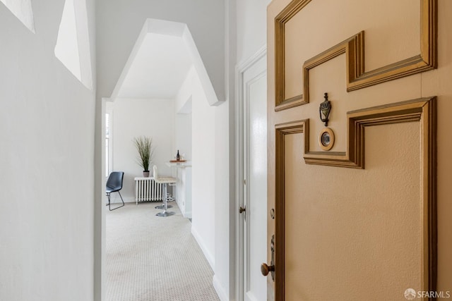 corridor featuring carpet floors and radiator heating unit