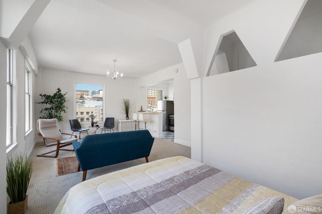 bedroom featuring carpet, stainless steel fridge, and a notable chandelier