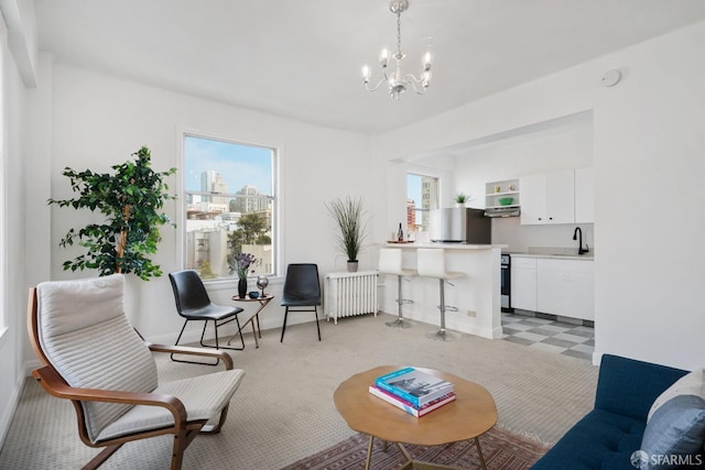 living room with light carpet, a notable chandelier, sink, and radiator heating unit