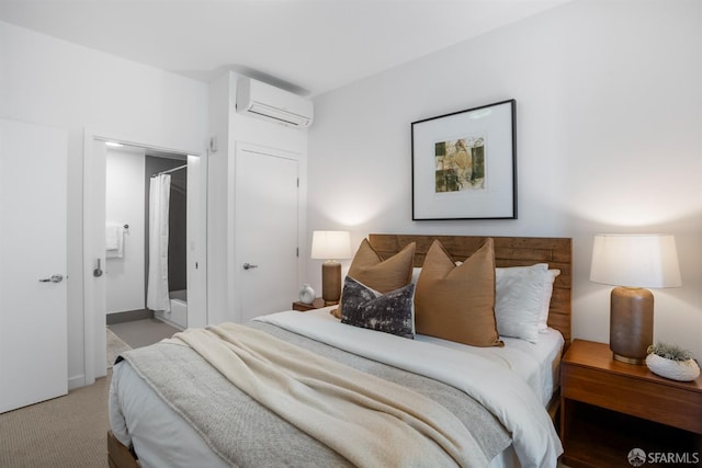 bedroom featuring an AC wall unit, ensuite bathroom, and carpet