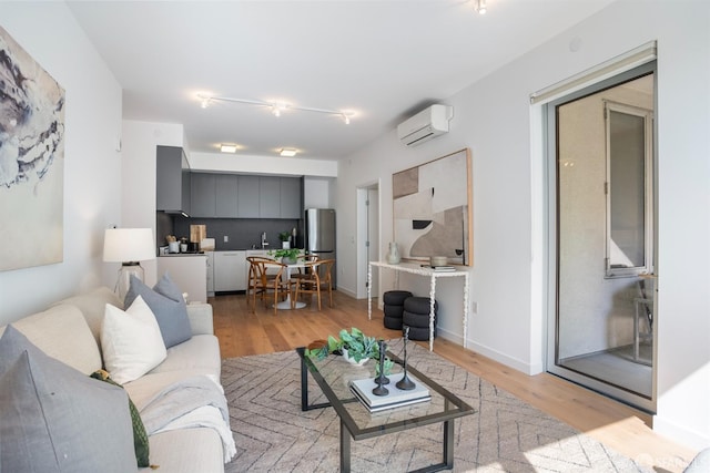 living room with a wall mounted air conditioner and light hardwood / wood-style floors