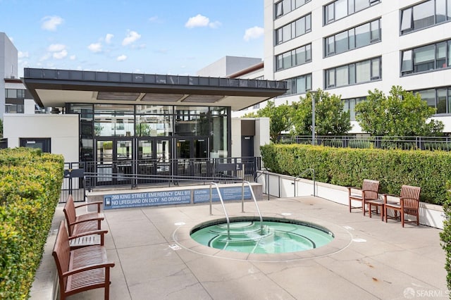 view of pool with a hot tub