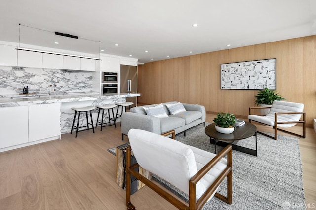 living room featuring wooden walls and light hardwood / wood-style flooring