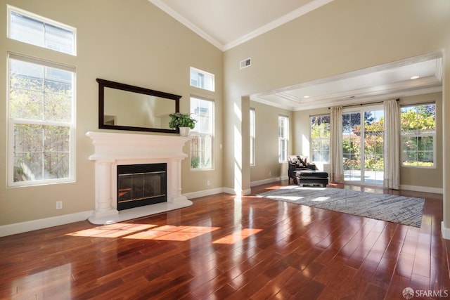 unfurnished living room with hardwood / wood-style flooring, crown molding, and high vaulted ceiling