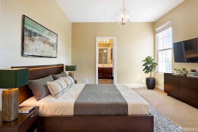 carpeted bedroom featuring ensuite bath, multiple windows, and a notable chandelier