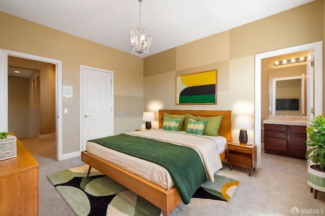 bedroom featuring connected bathroom, light carpet, and a chandelier