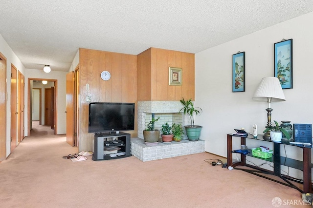 living room featuring a textured ceiling, light colored carpet, and wood walls