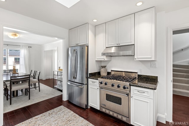 kitchen with appliances with stainless steel finishes, white cabinets, under cabinet range hood, and dark wood-style floors