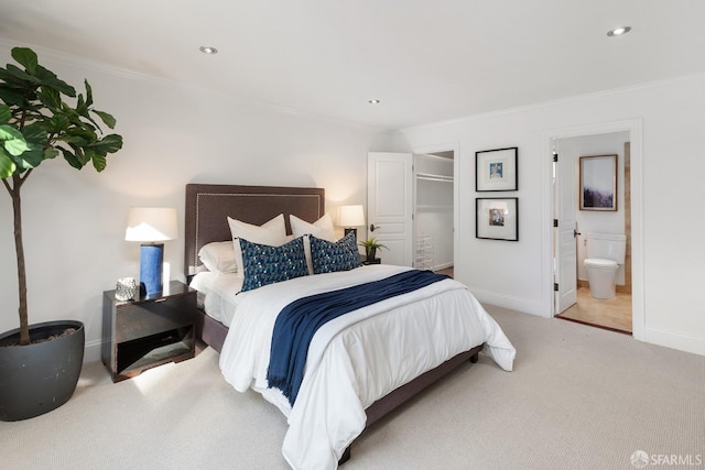 bedroom with carpet floors, crown molding, recessed lighting, ensuite bath, and baseboards